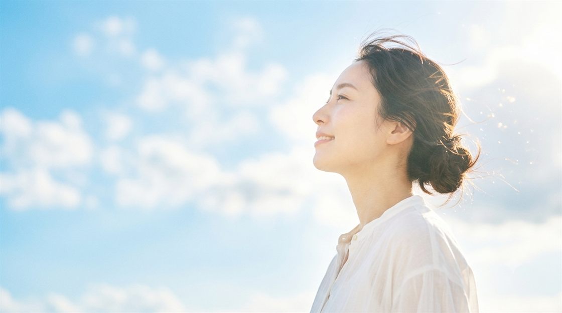 青空を見上げる女性の横顔
